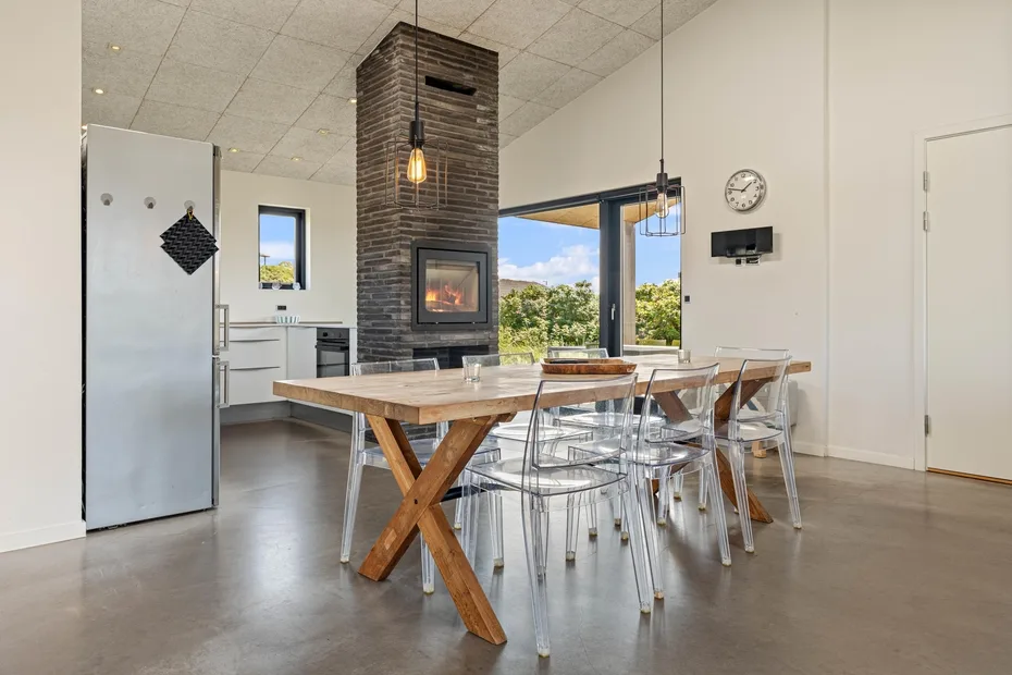 Una cocina abierta y comedor con una mesa de madera y chimenea.
