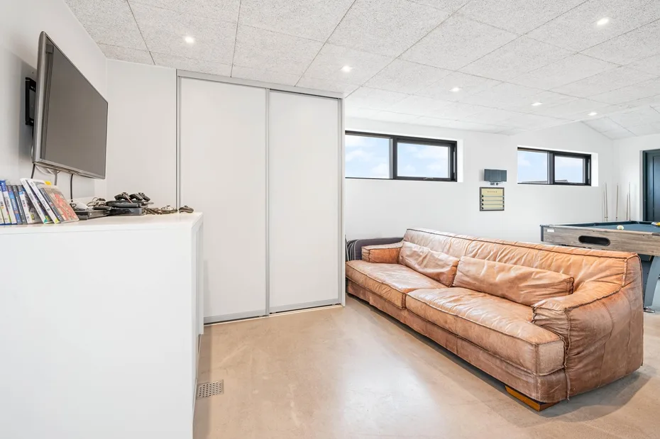 Una sala de recreación con una zona de asientos de cuero y una mesa de billar.
