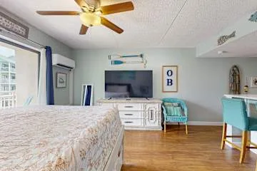 Un dormitorio con cama, televisión y zona de estar.