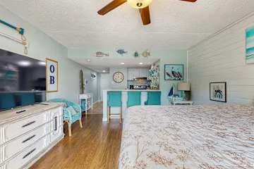 Un dormitorio con una cama grande, una cómoda y una pequeña zona de mostrador.