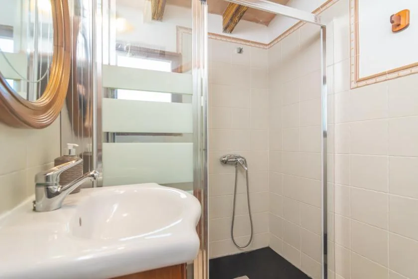 A bathroom with a sink and a tiled shower.