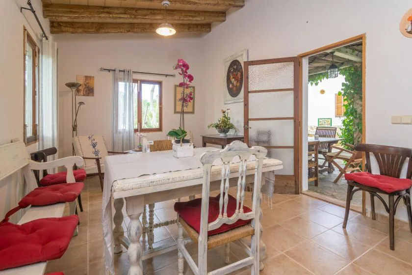 A dining room with a table and chairs beside an open doorway to a patio.