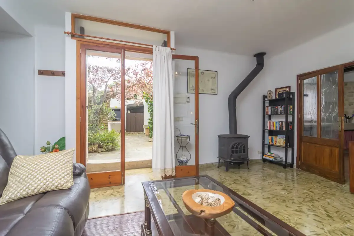 Living room with seating, a coffee table, and a wood-burning stove.