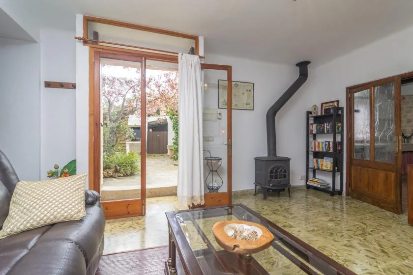 A living room with a glass coffee table and a wood-burning stove.
