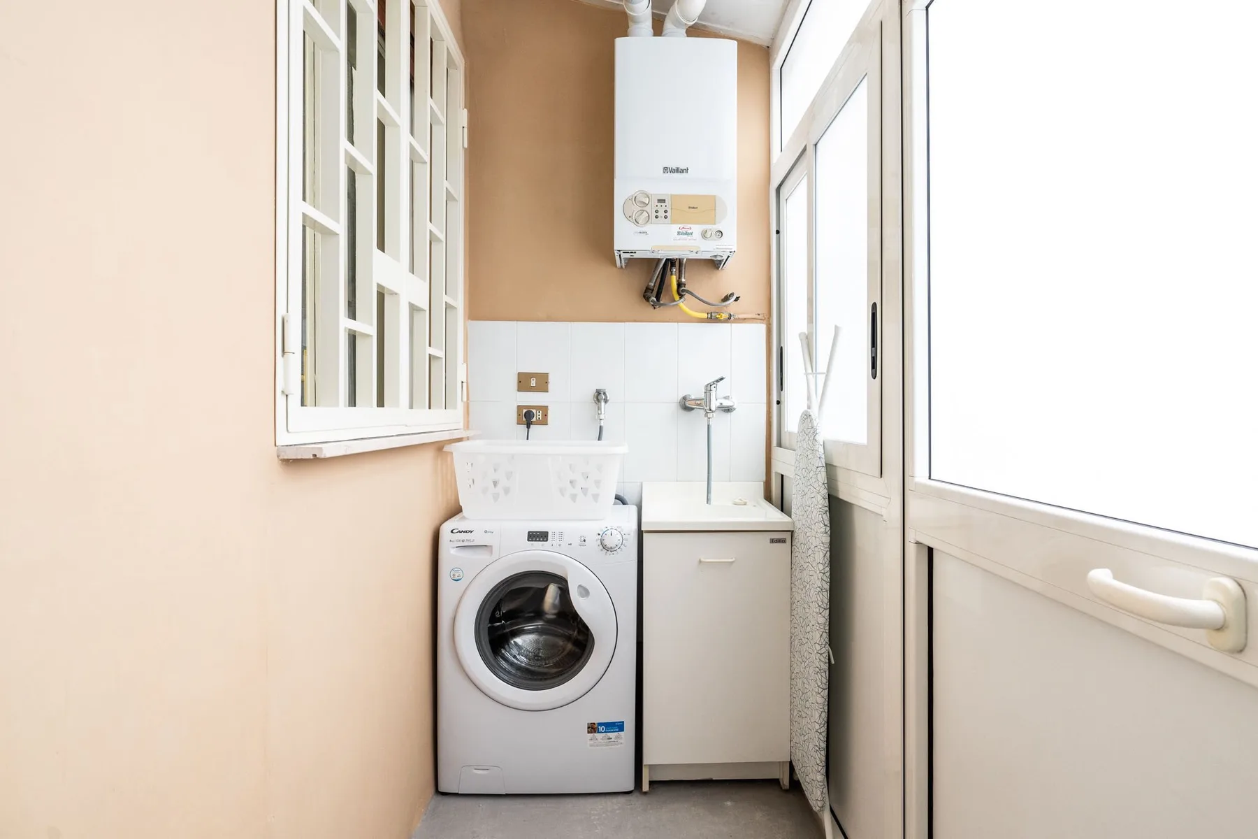 A laundry area with a washing machine beside a utility sink.