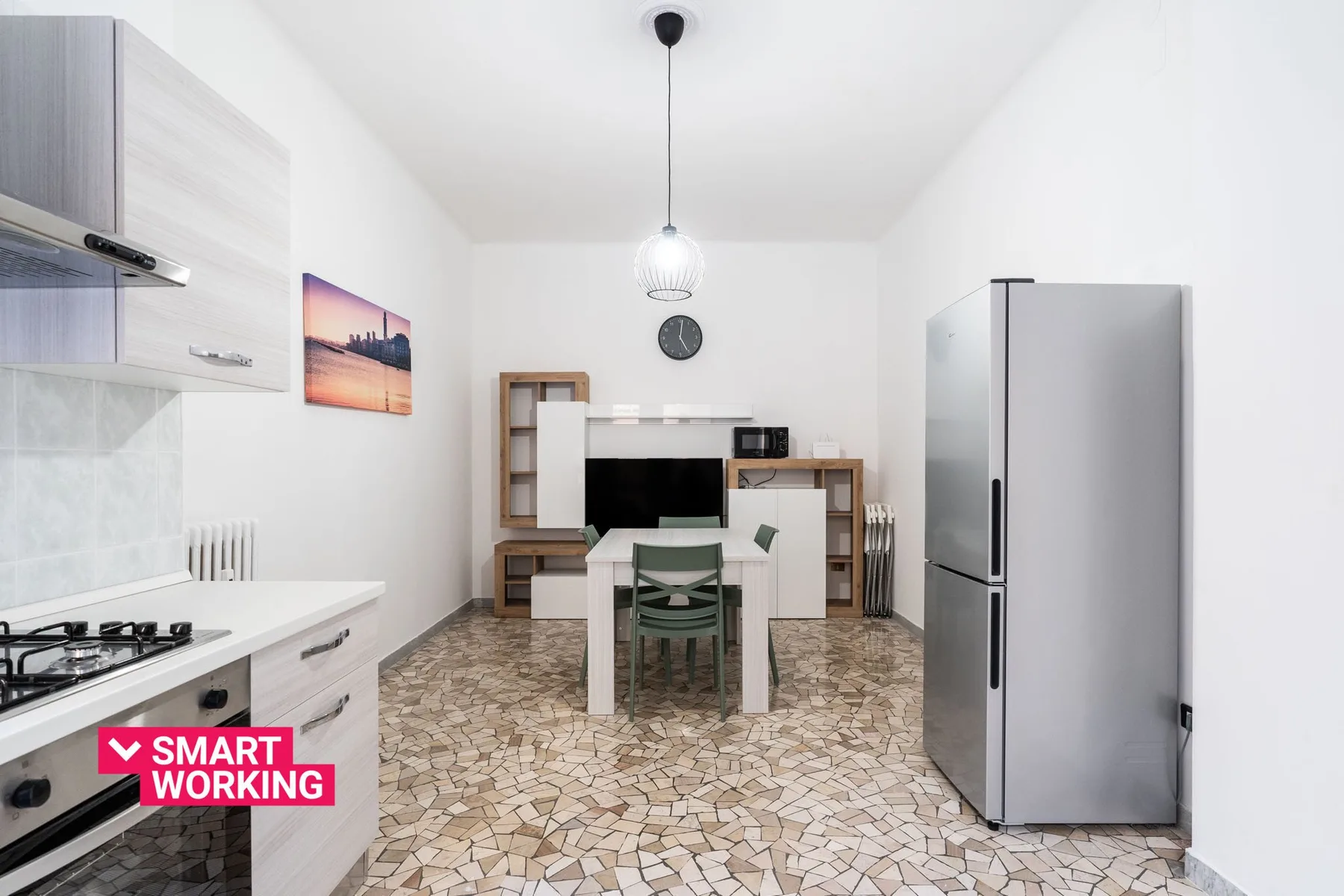 A bright kitchen and dining area with a table, chairs, and refrigerator.
