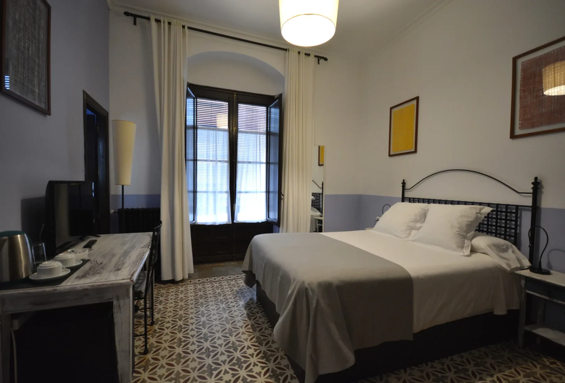 Pacífico room with a queen-size bed and window facing the façade