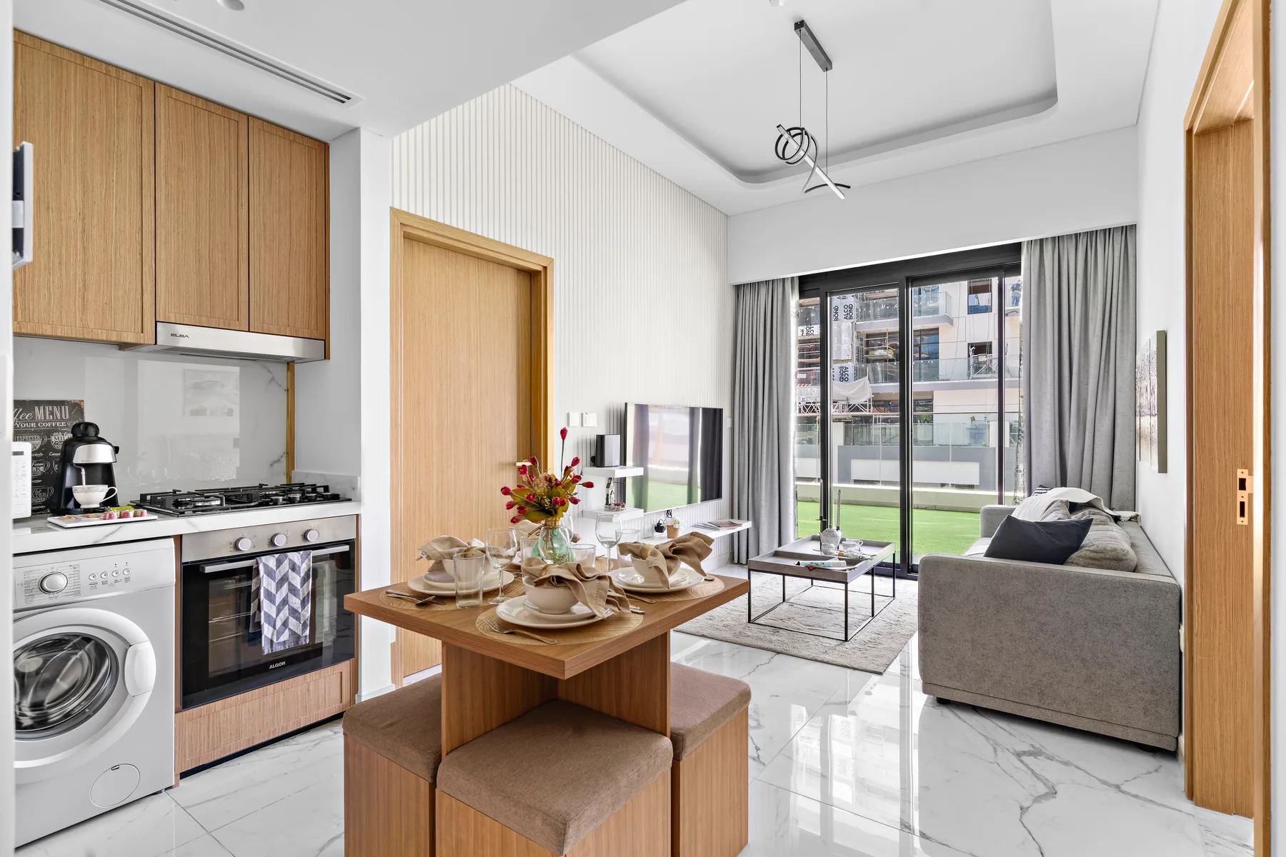 A bright living and dining area with a kitchen and large windows.
