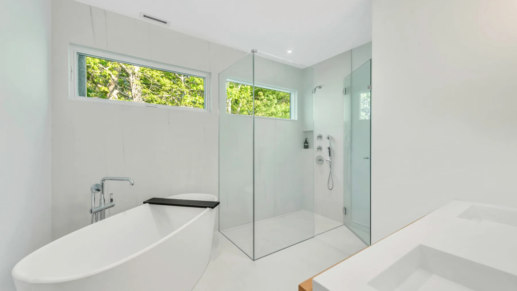 Un baño luminoso con bañera y ducha de vidrio.