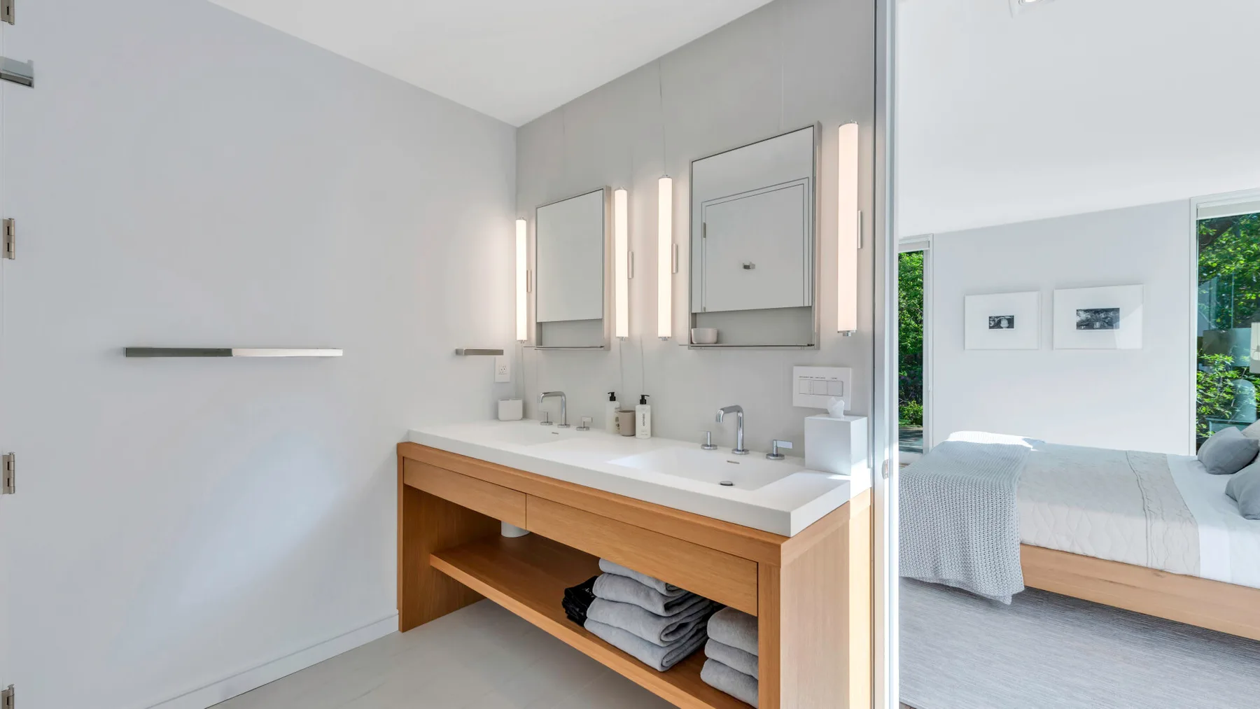 Un baño luminoso con un tocador largo y un espejo grande.