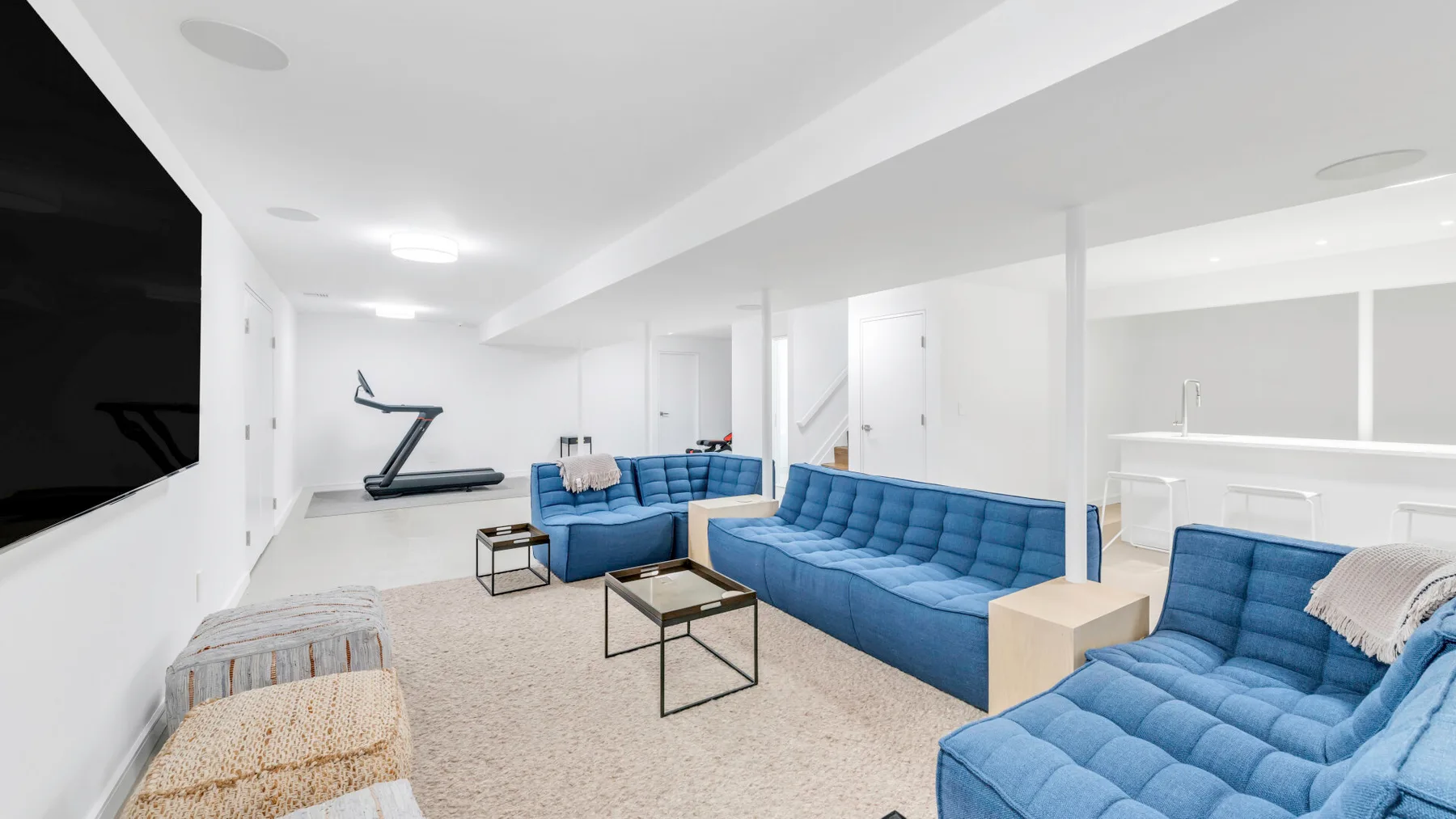 Una sala luminosa con asientos azules y una mesa de centro.