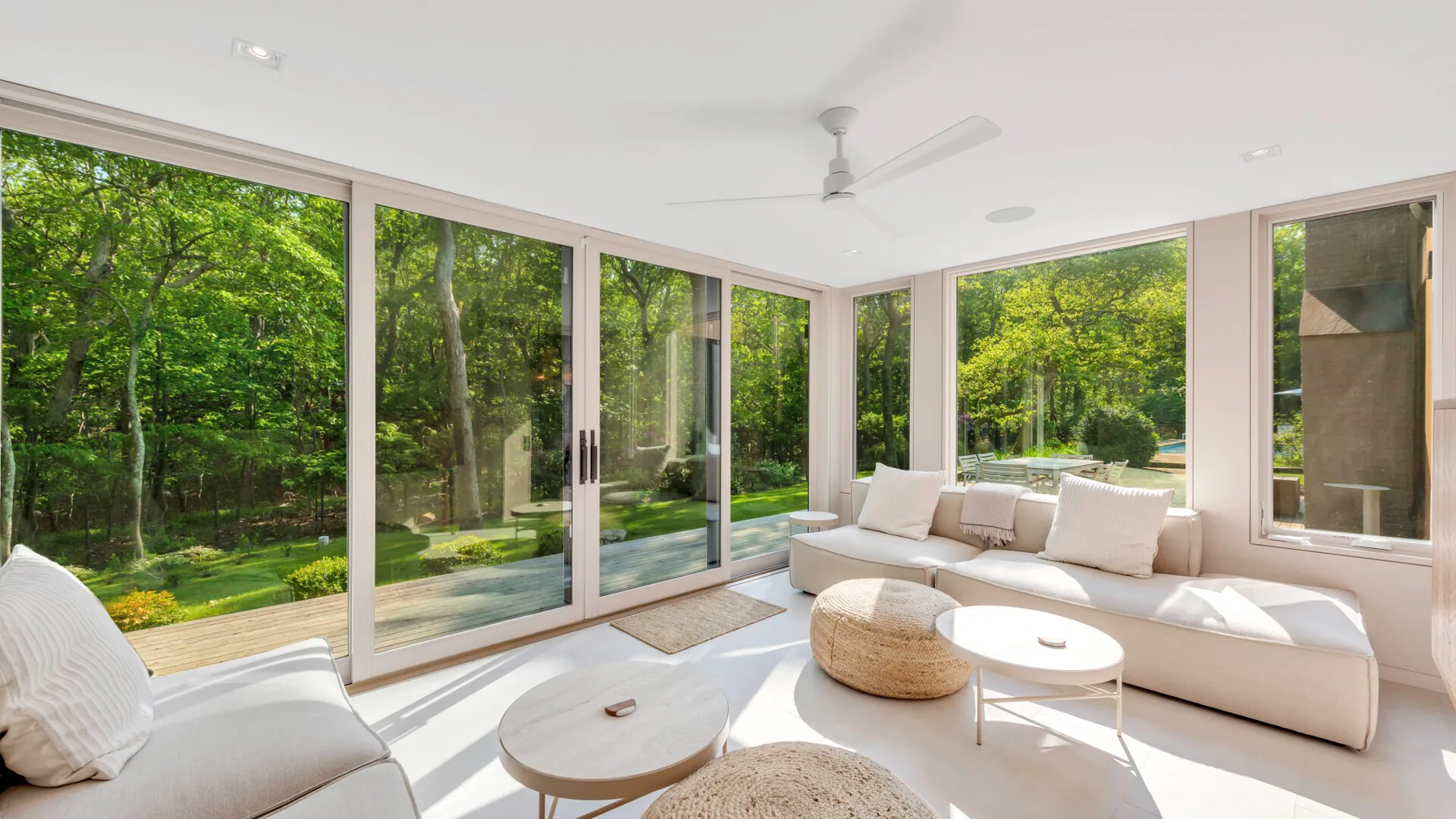 Una sala luminosa con asientos junto a grandes ventanas que dan a la vegetación.