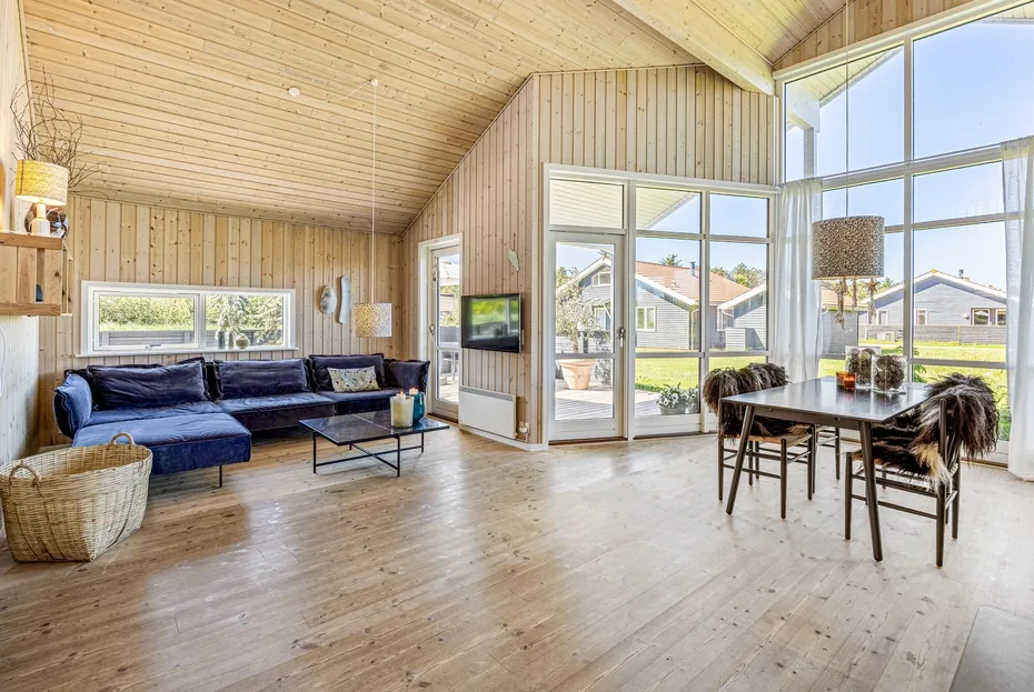 A bright living and dining area with large windows and a seating area.
