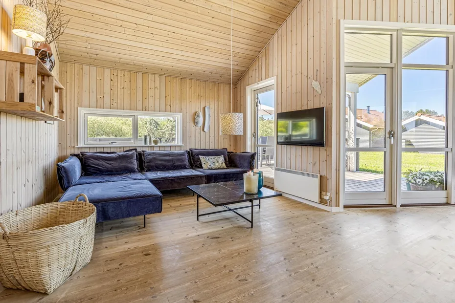 A living room with a sectional sofa, coffee table, and glass doors opening onto a patio.