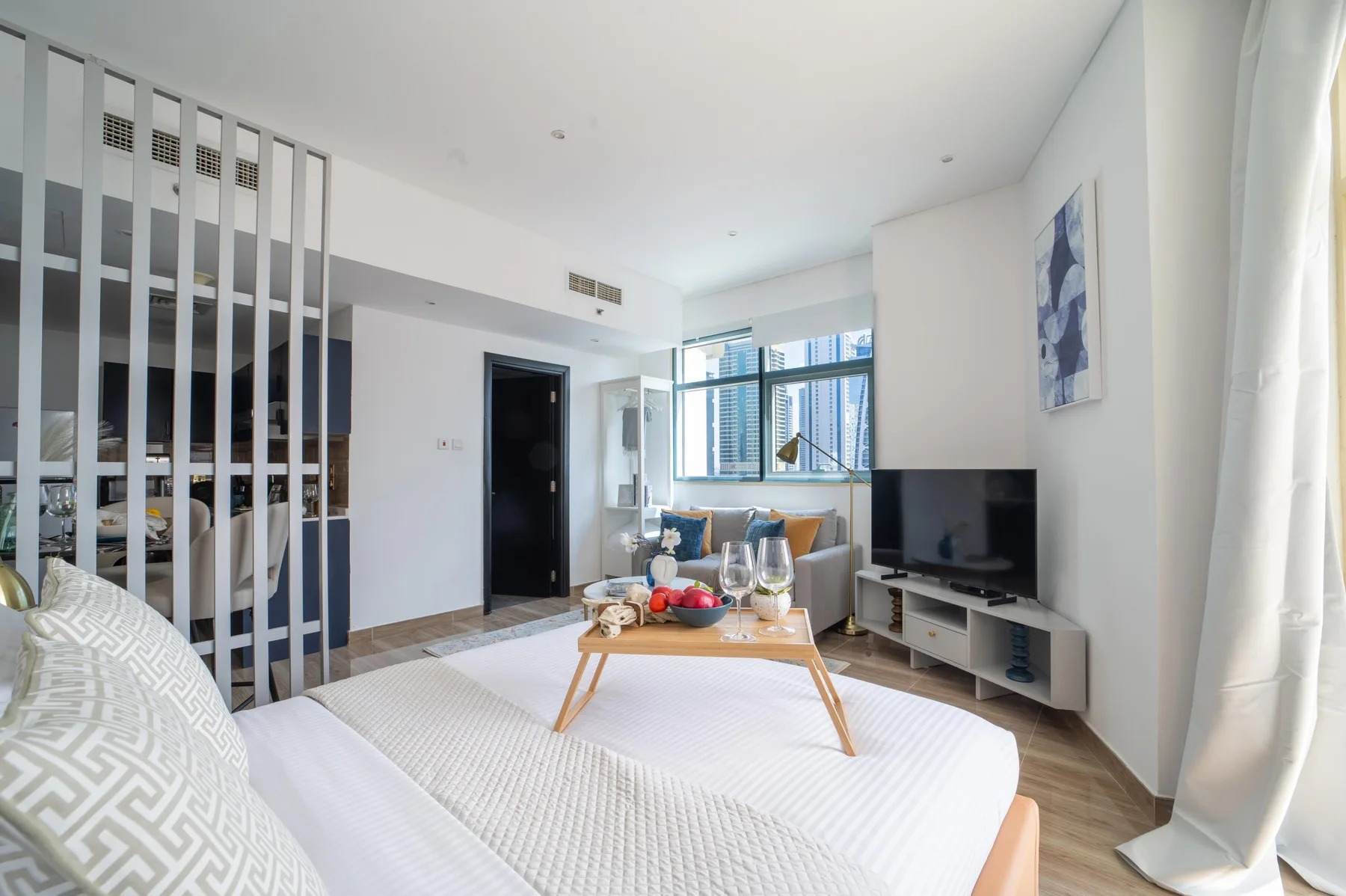Un dormitorio luminoso con una mesa baja y un televisor junto a la cama.