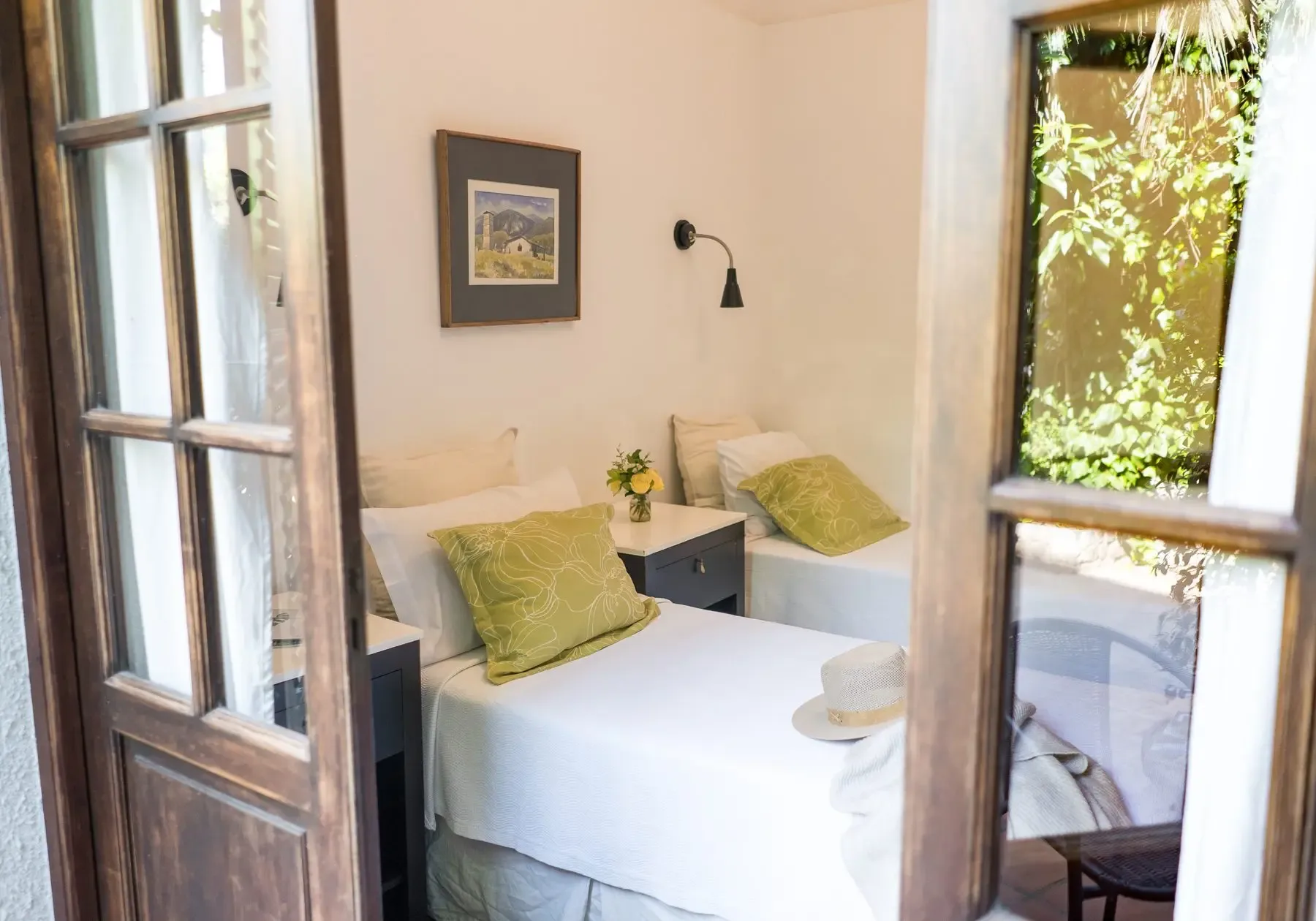 Habitación con dos camas individuales y puertas francesas al jardín