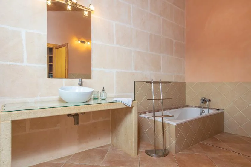 A bathroom with a sink, mirror, and bathtub.
