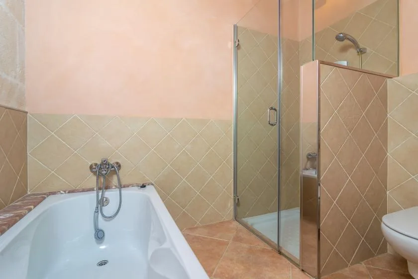 A bathroom with a bathtub and glass shower.