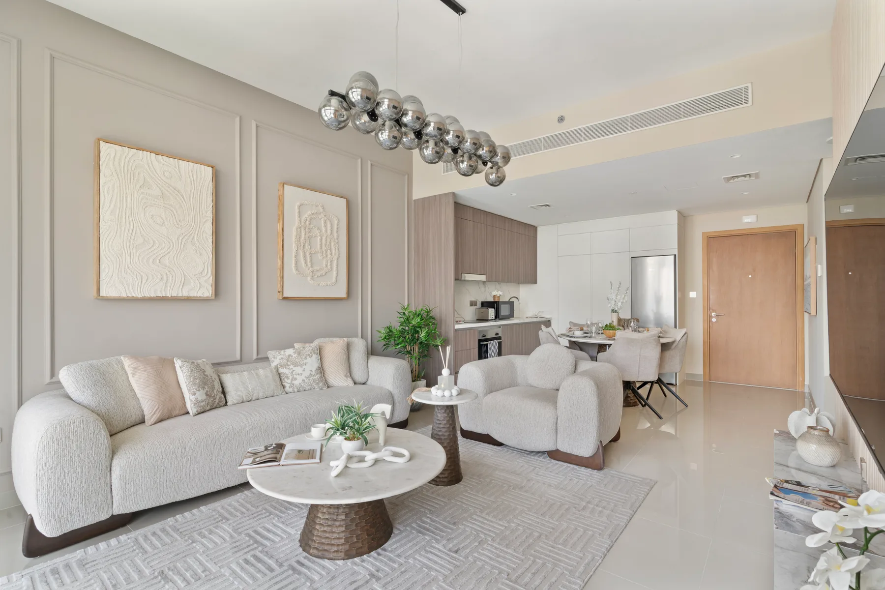 A bright living room with upholstered seating and a dining area beyond.