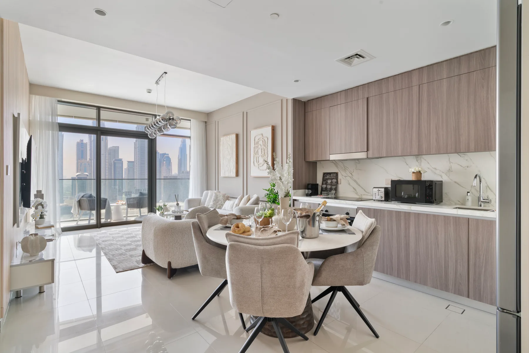 A bright open-plan living and kitchen area with seating beside large windows.