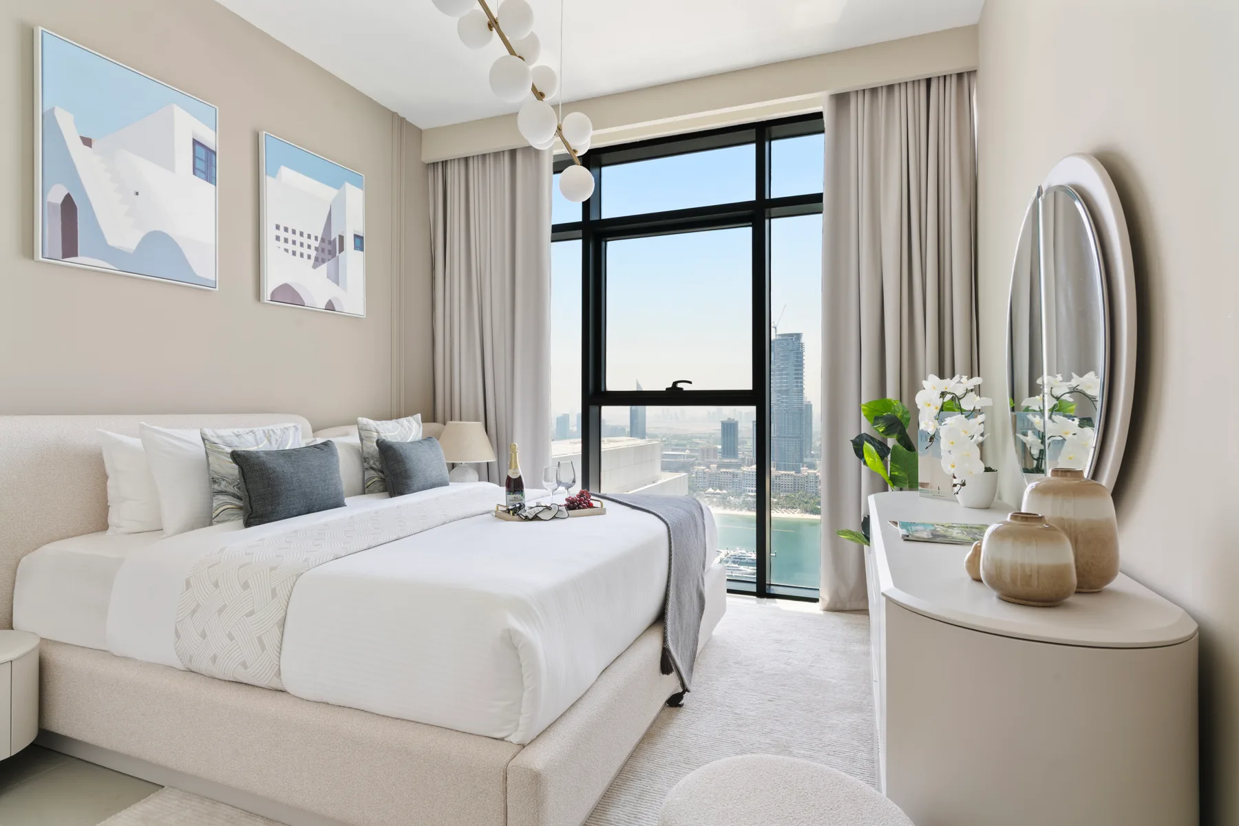 A bright bedroom with a large bed beside a floor-to-ceiling window.