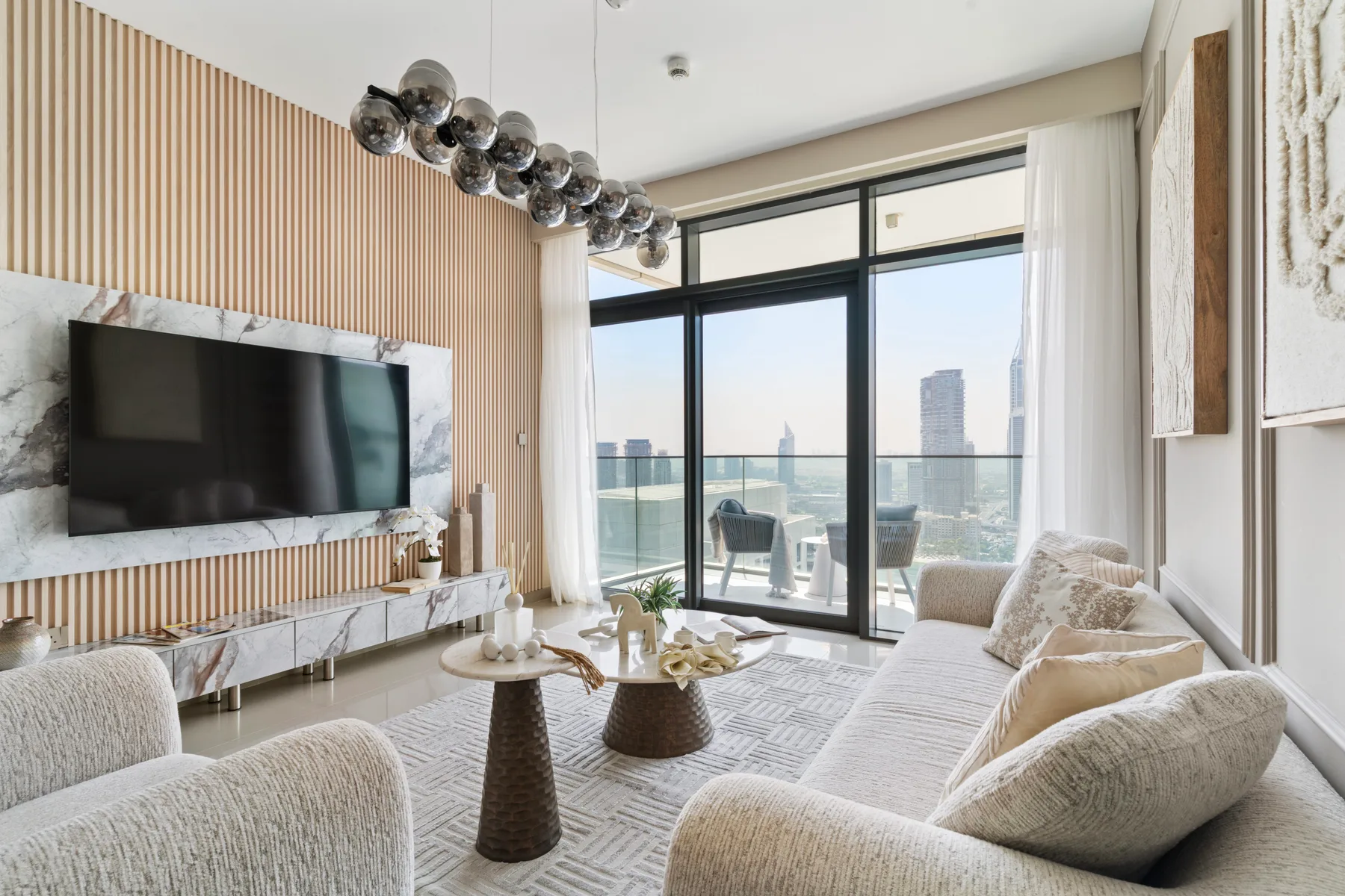 A bright living room with large windows, seating, and a view of the water.