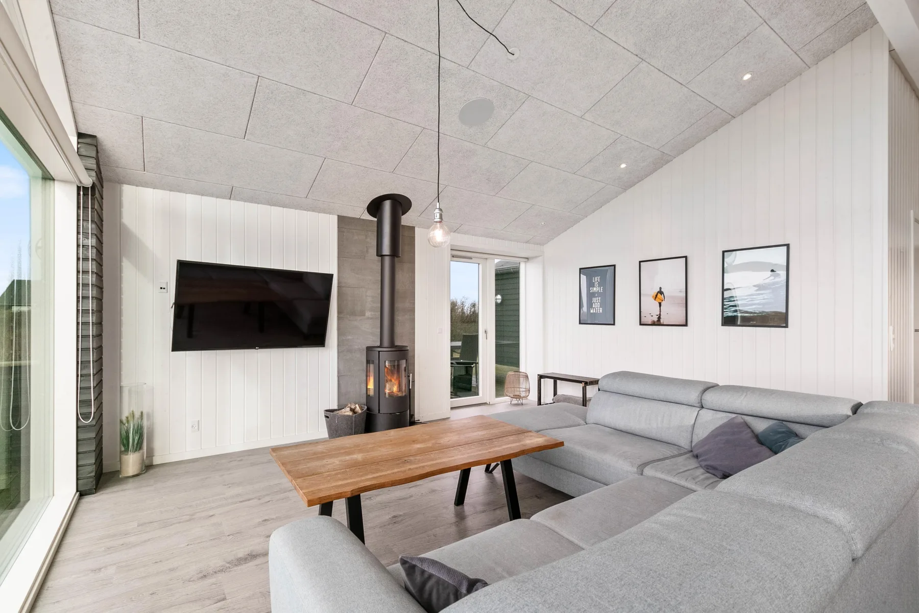 Una sala luminosa con zona de asientos, mesa de centro y chimenea.