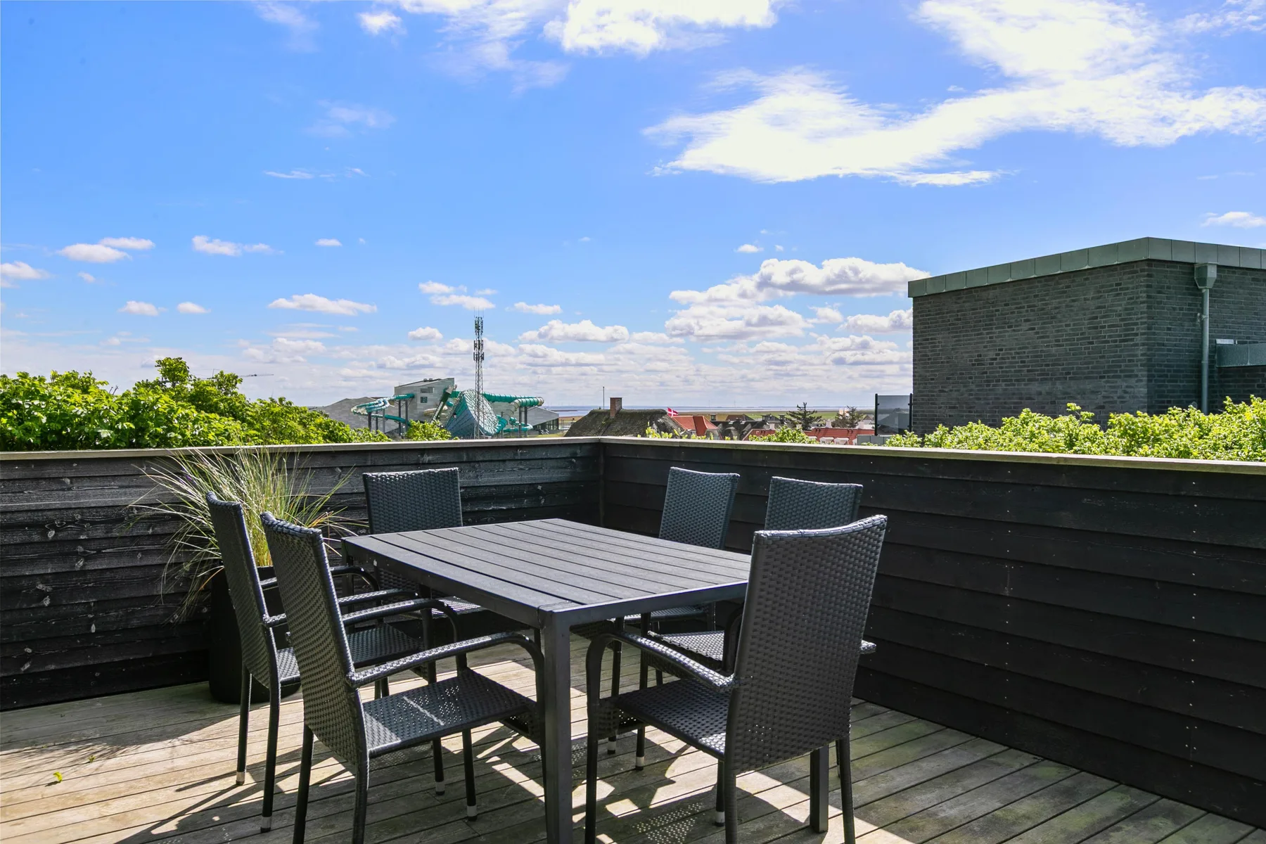 Una terraza en la azotea con mesa de comedor y asientos al aire libre.