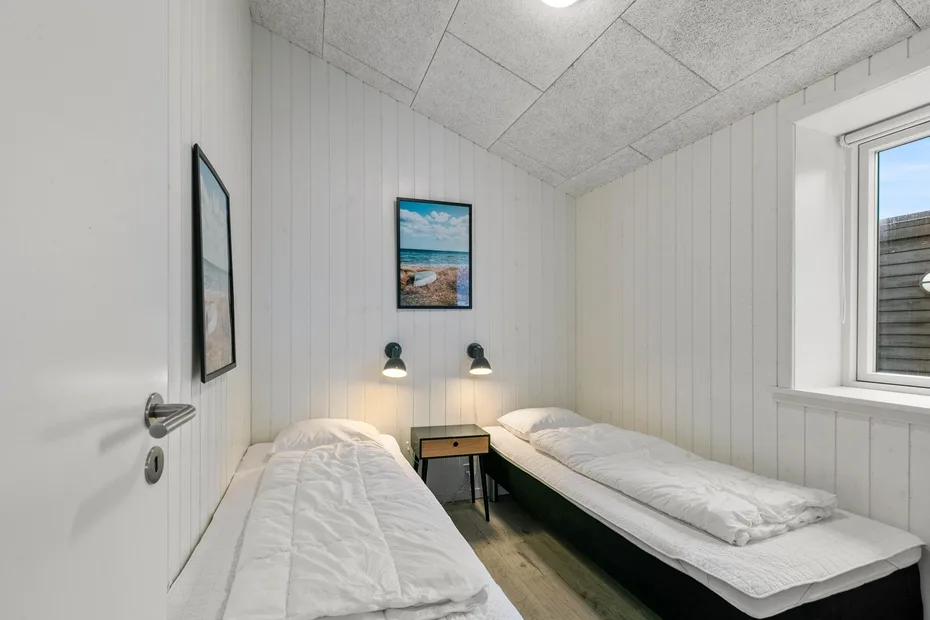 Un dormitorio compacto con dos camas individuales y una mesita entre ellas.