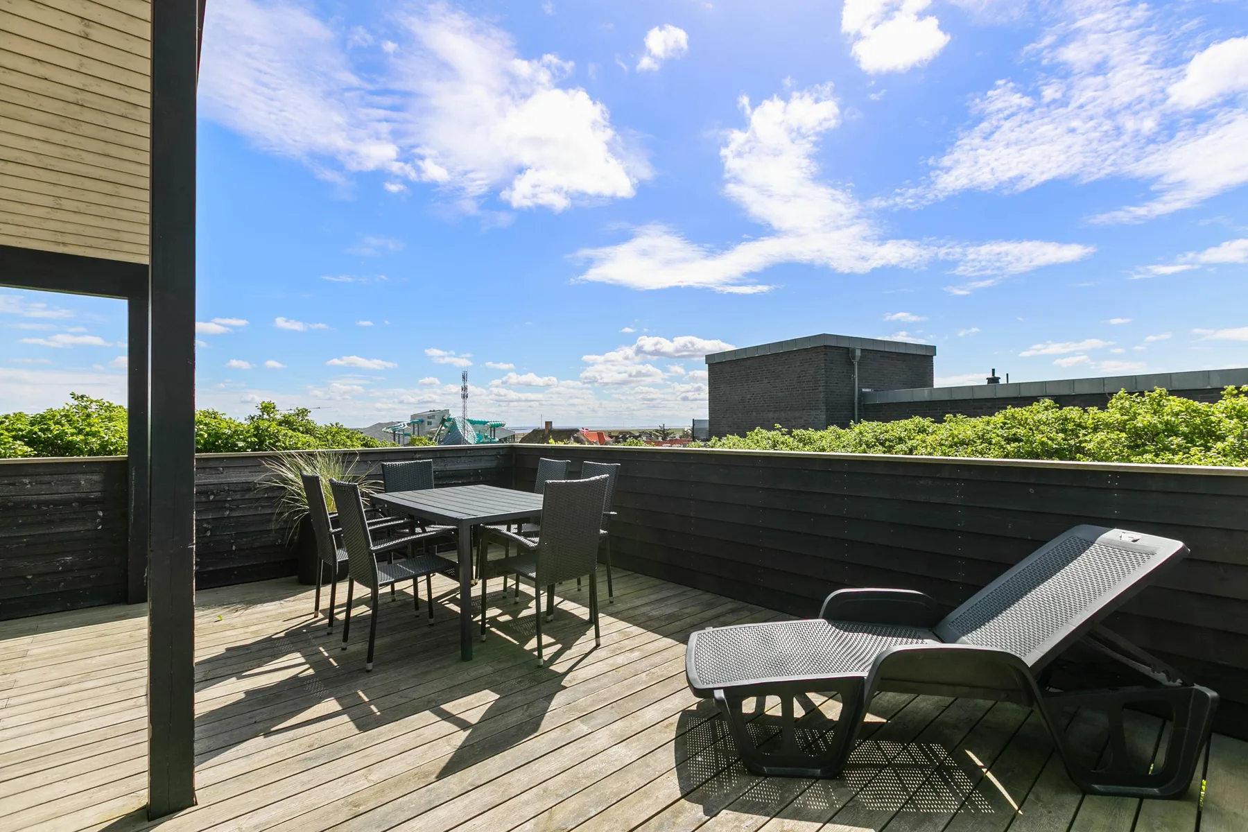 Una terraza en la azotea con asientos al aire libre y vista al cielo.