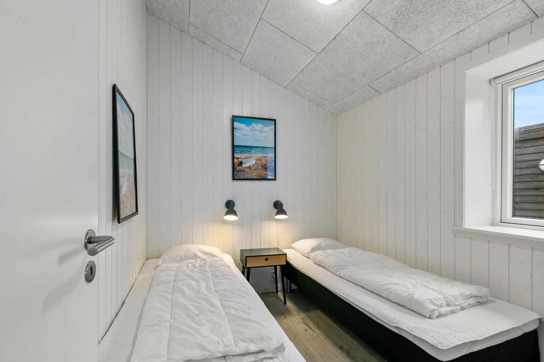 Un dormitorio con dos camas individuales y una pequeña mesa entre ellas.