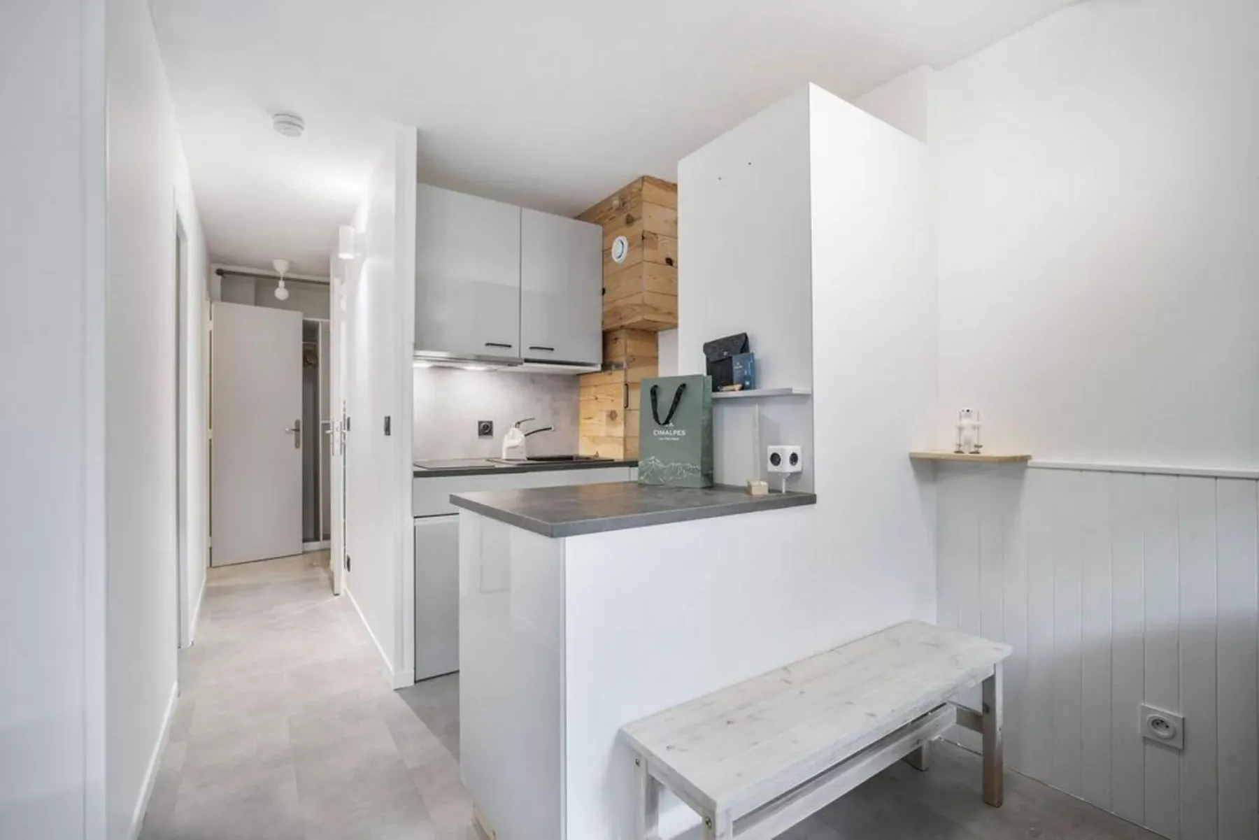 Una cocina luminosa con una barra y un pasillo al lado.