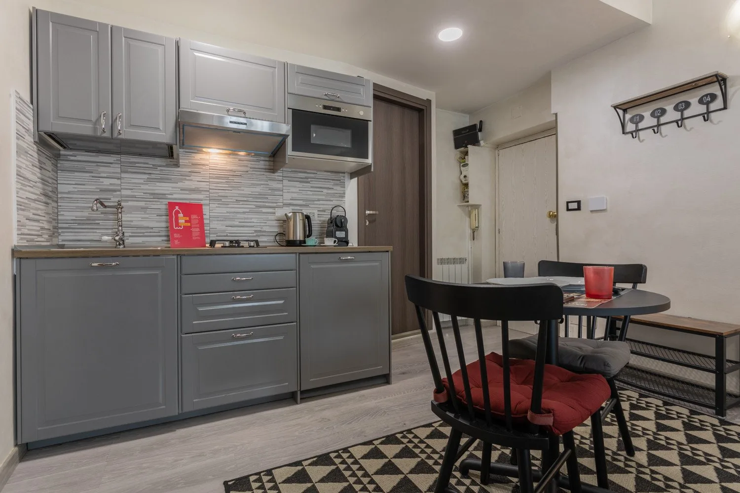 A compact kitchen and dining area with gray cabinets and a small table.