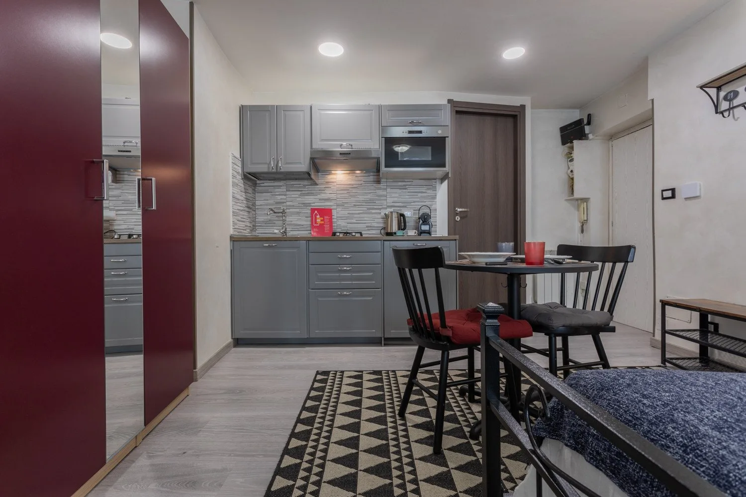 A kitchen and dining area with gray cabinets and a table beside the seating area.