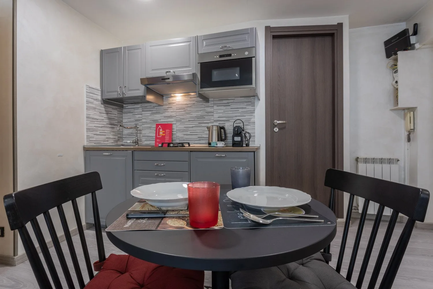 A compact kitchen and dining area with a round table set for a meal.