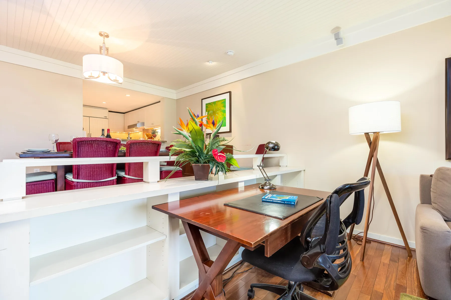 Comedor con una mesa de madera, sillas y flores de colores.