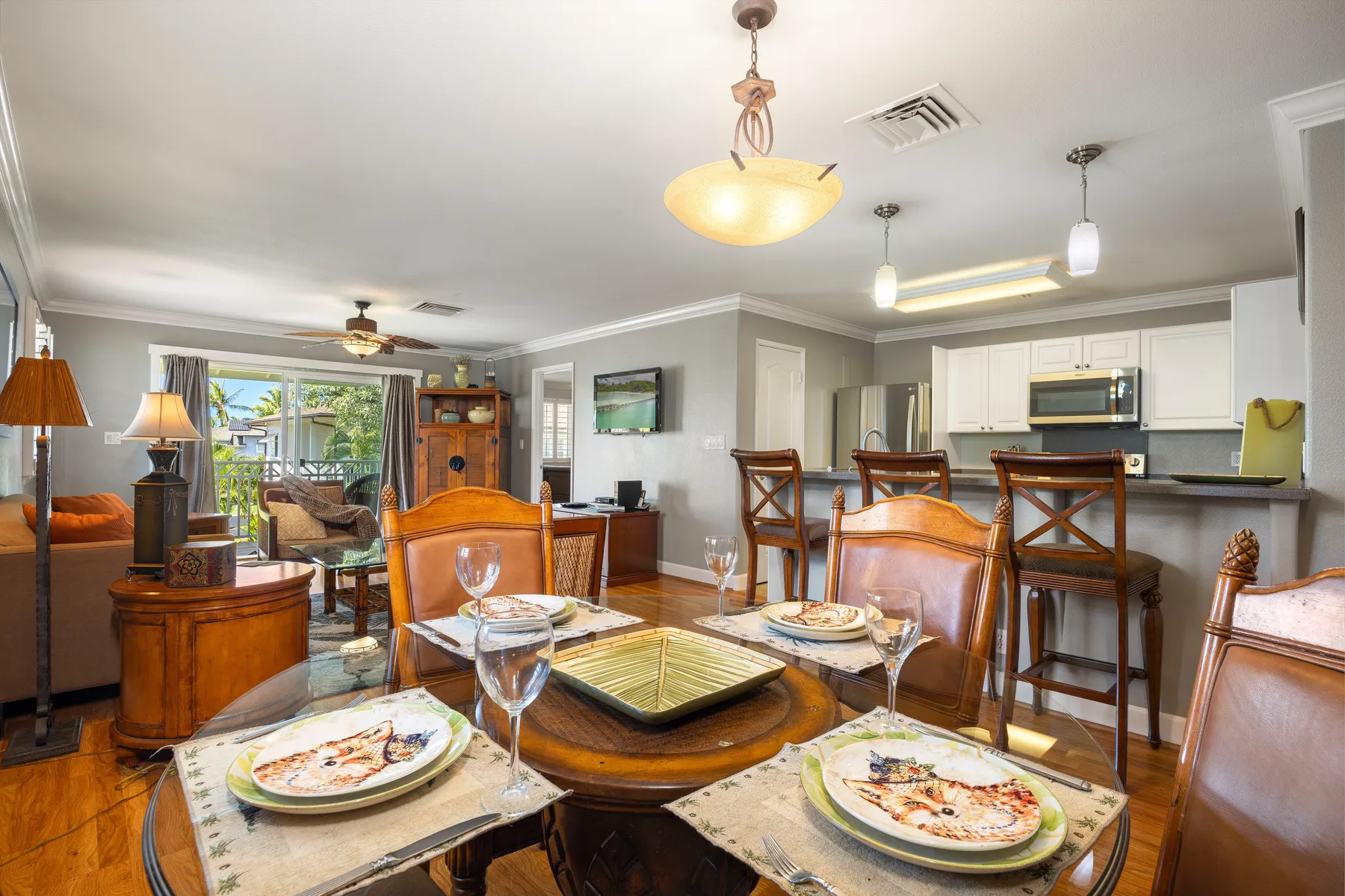 Comedor con la mesa puesta y una cocina abierta al fondo.