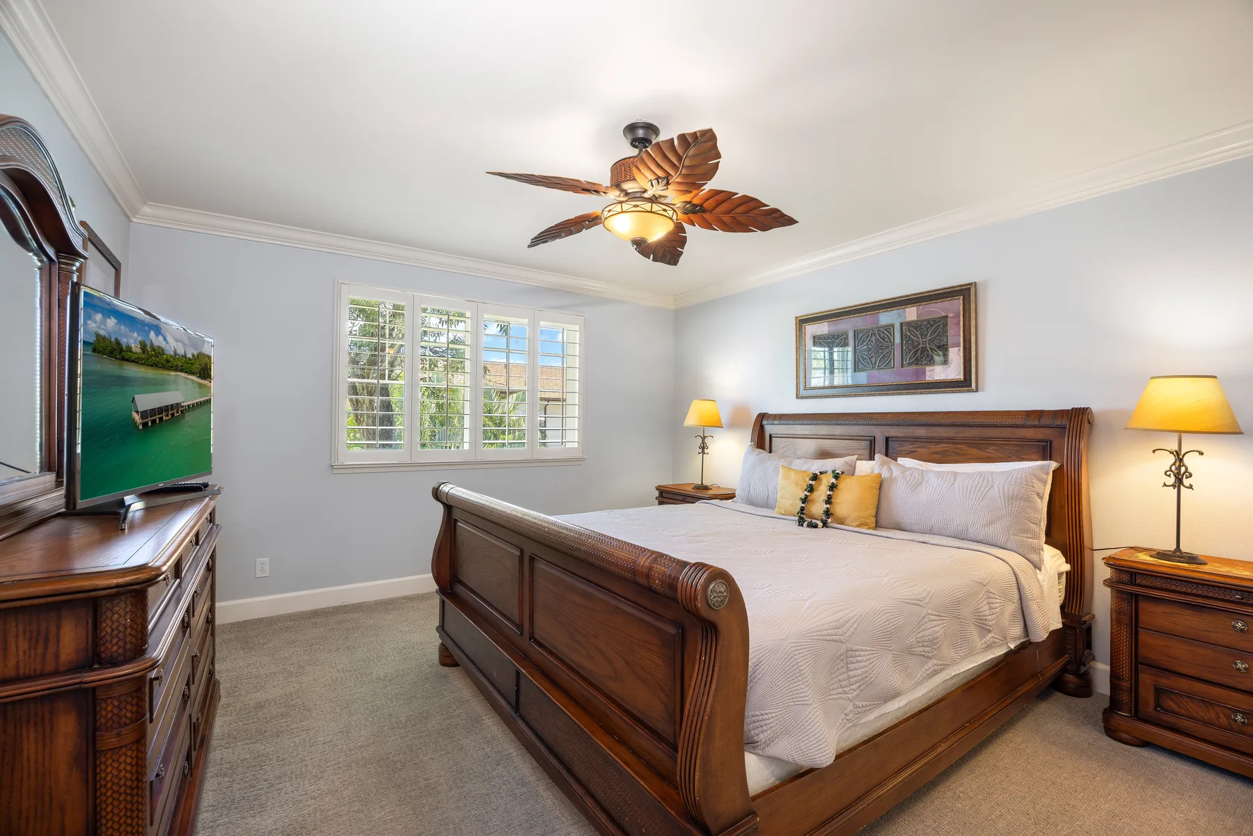 A bedroom with a wooden bed, matching bedside tables, and a window.