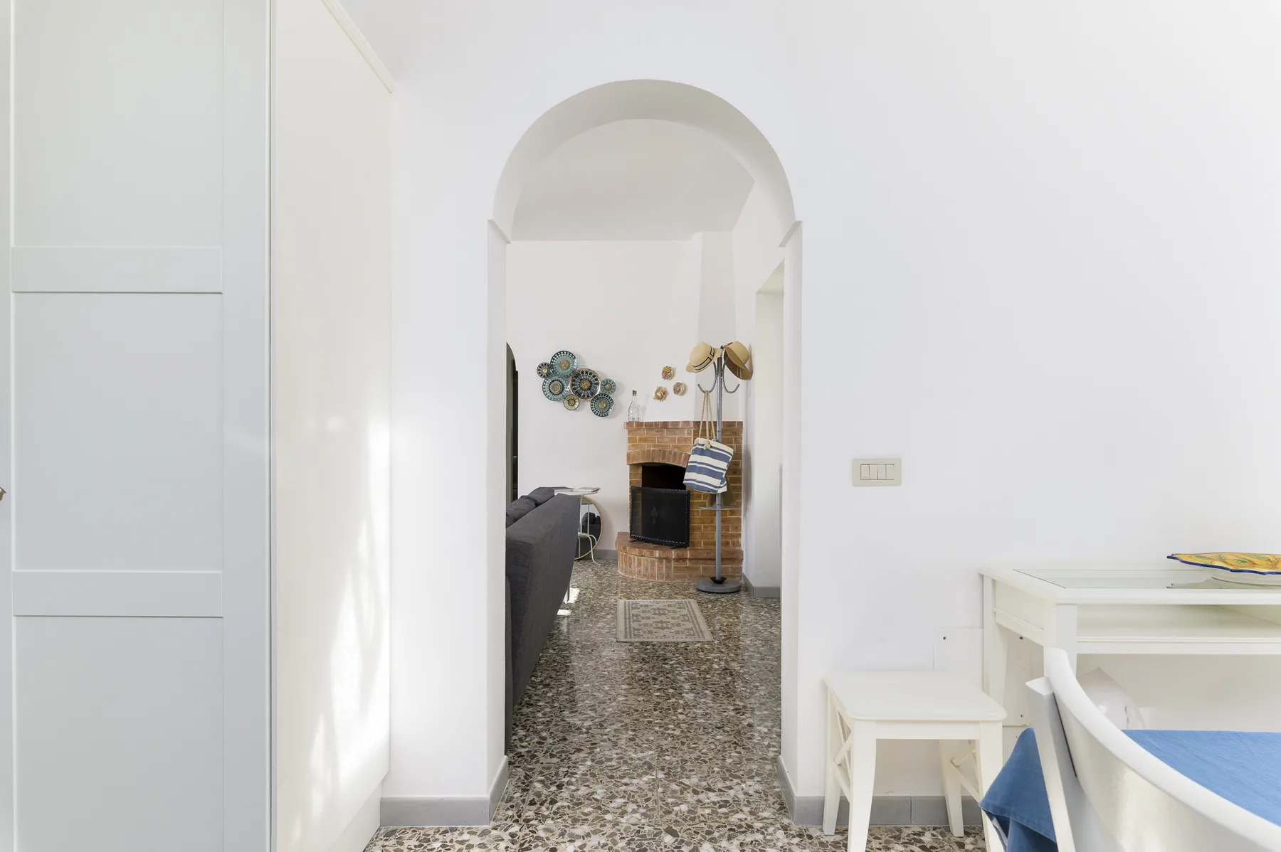 A bright interior hallway opens into a living area through an arched doorway.