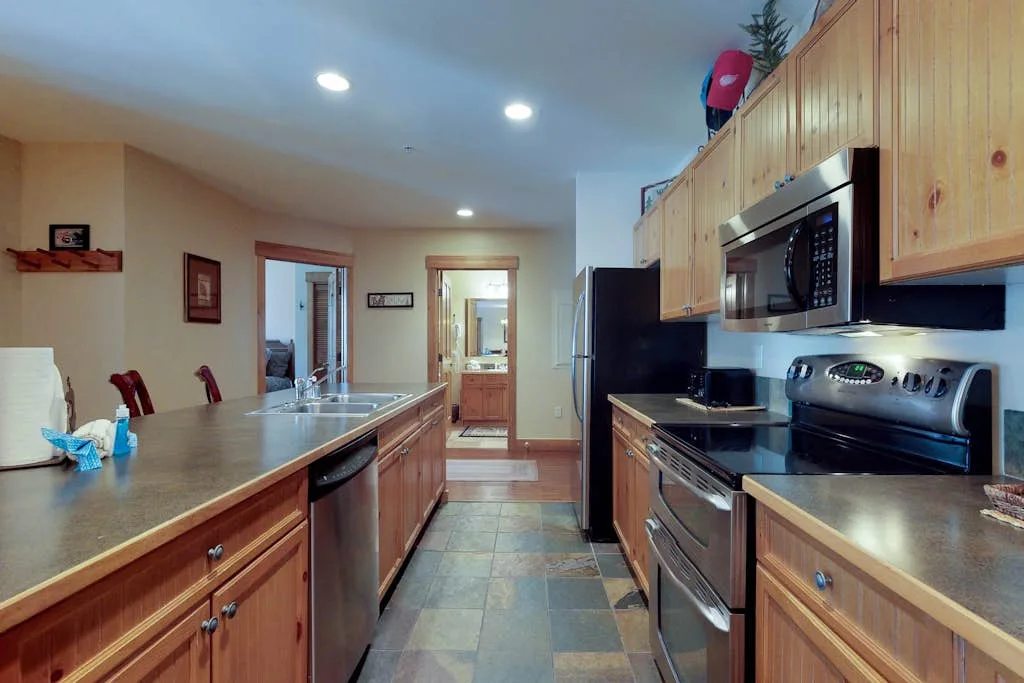 A spacious kitchen with wooden cabinets, a central island, and stainless steel appliances.