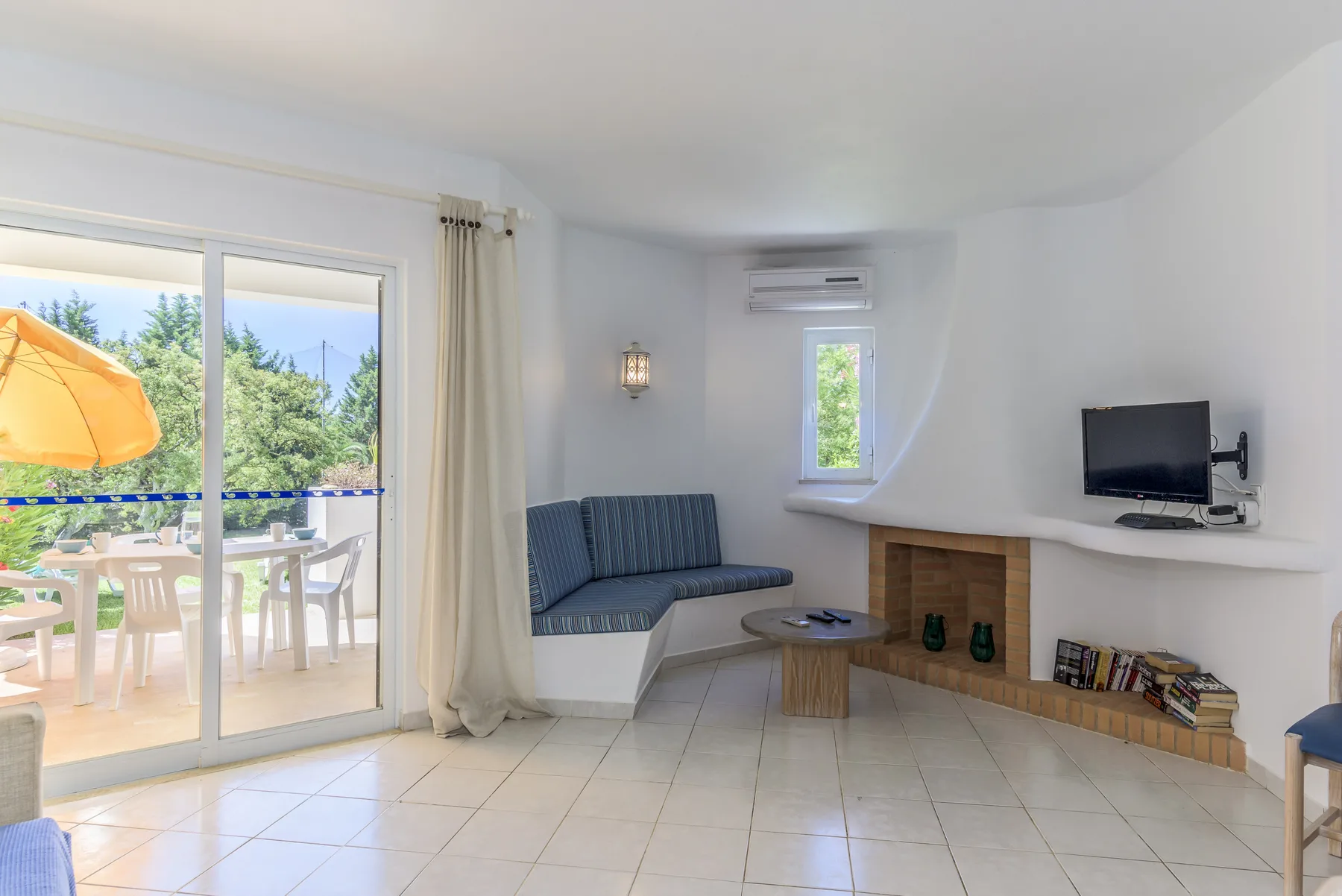 A bright living room with a built-in seating area and a television.