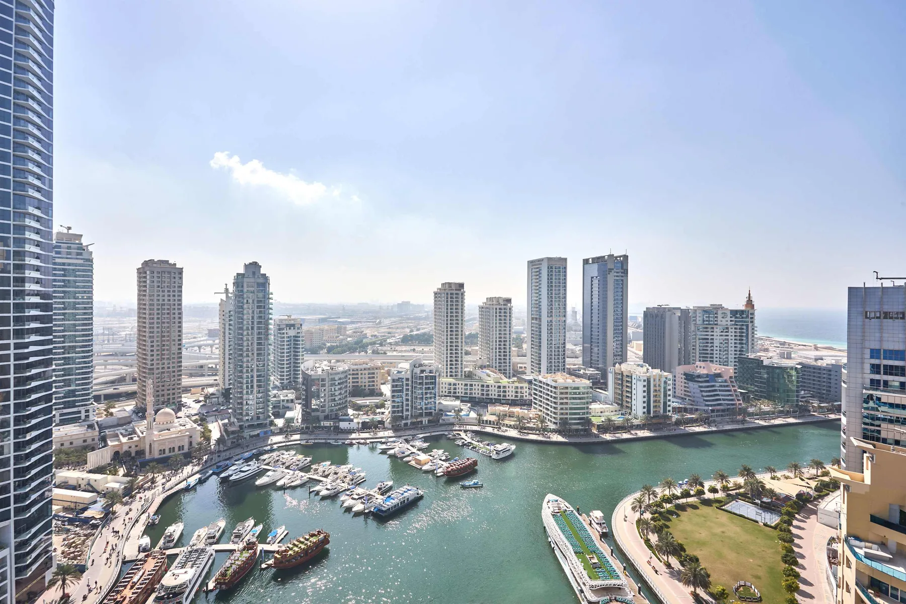 Vista aérea de un horizonte urbano junto al agua, con edificios altos y una marina.