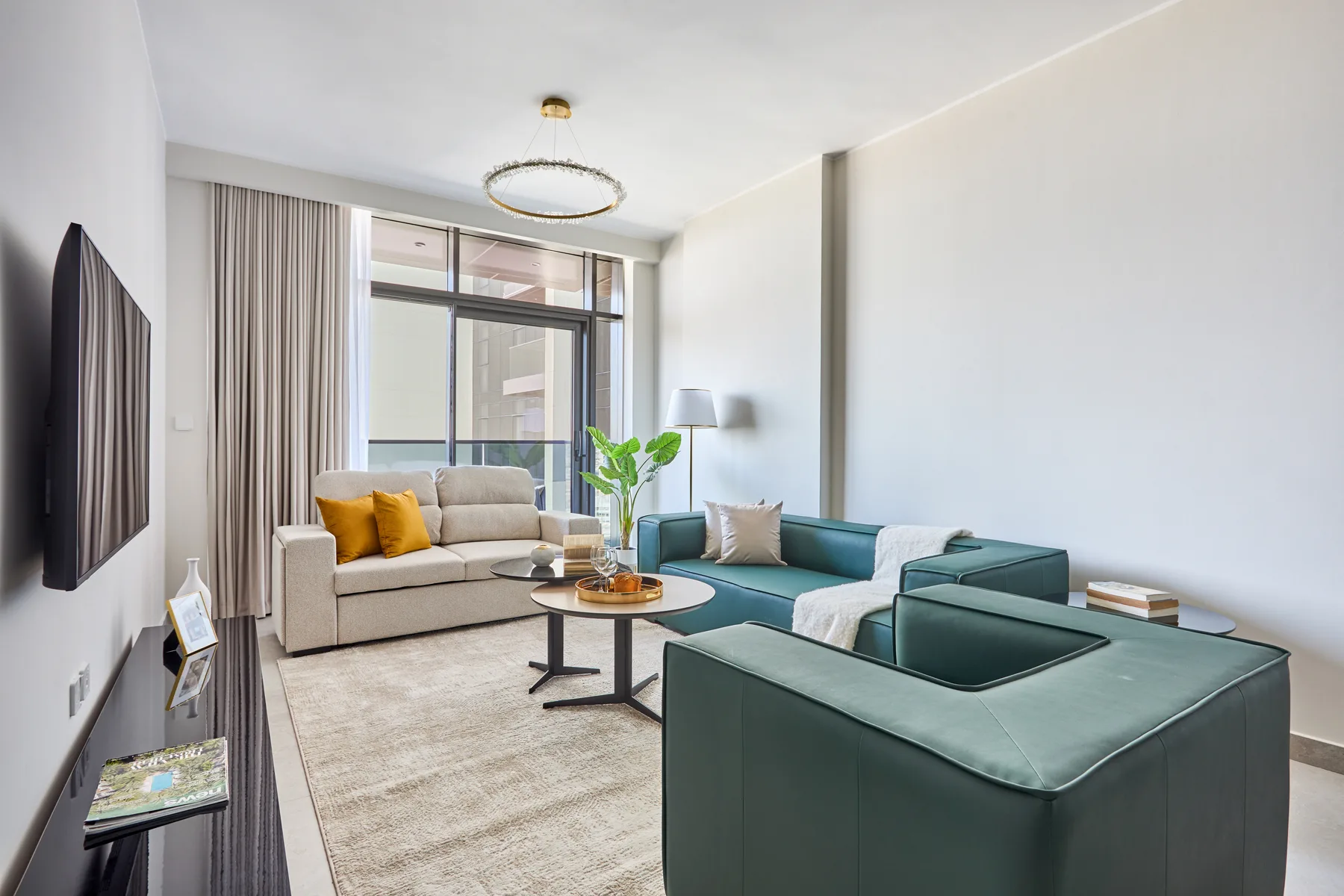 Sala de estar luminosa con sofá y sillones alrededor de una mesa de centro.