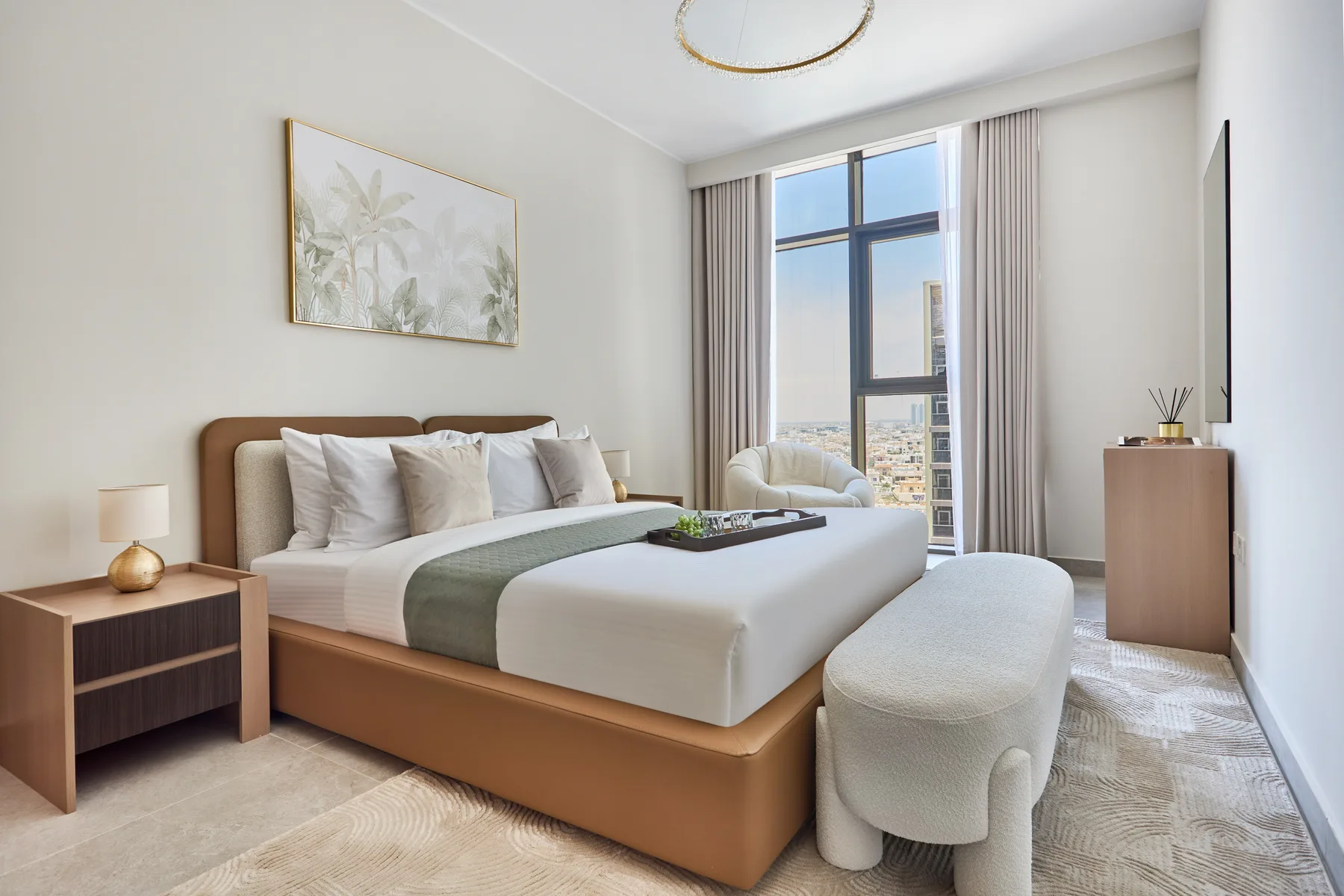 Un dormitorio luminoso con una cama bien hecha y una ventana grande.