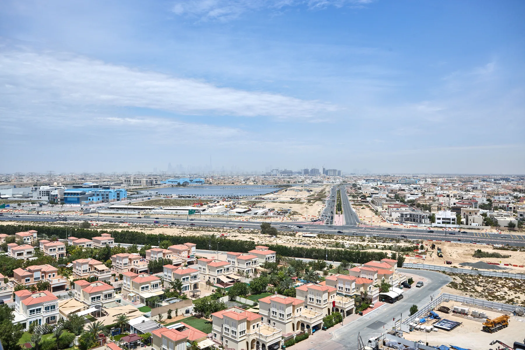 Una vista aérea muestra un barrio residencial junto a una vía principal.