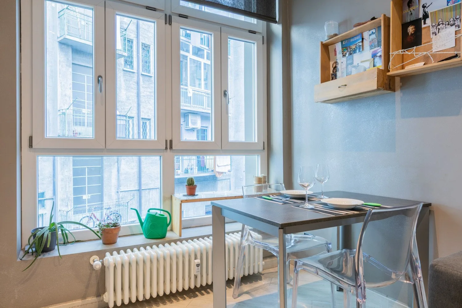 A dining area with a table and chairs beside large windows.