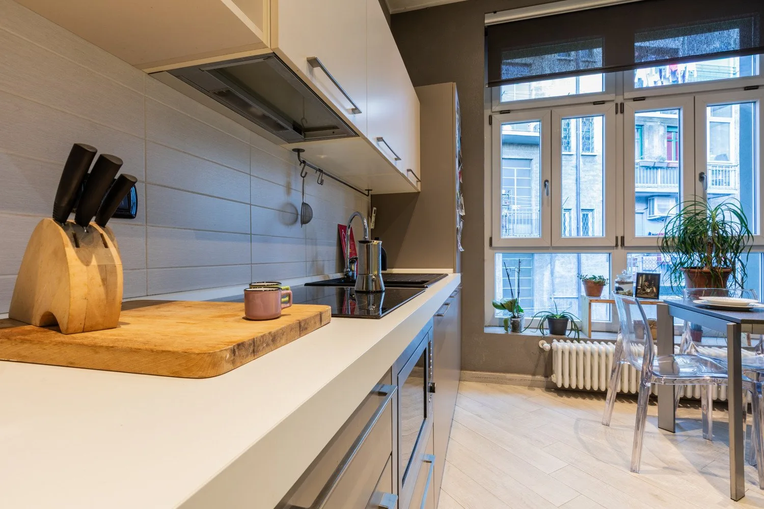 A bright kitchen with a long counter and a dining area by the windows.