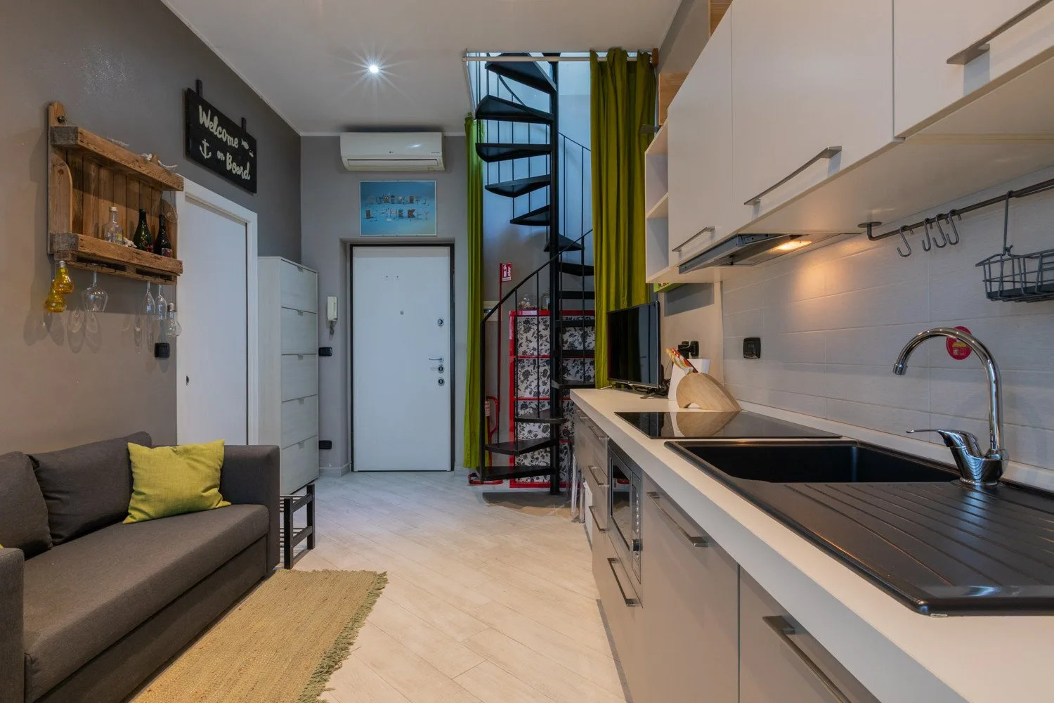 A compact kitchen and living area with a counter, sink, and seating.