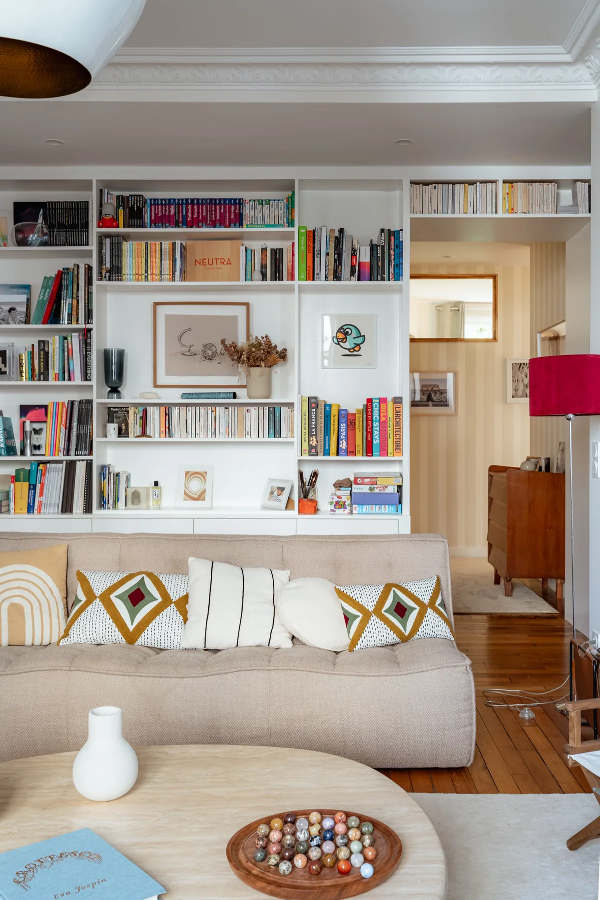 A living room with a sofa, bookshelves, and a round coffee table.