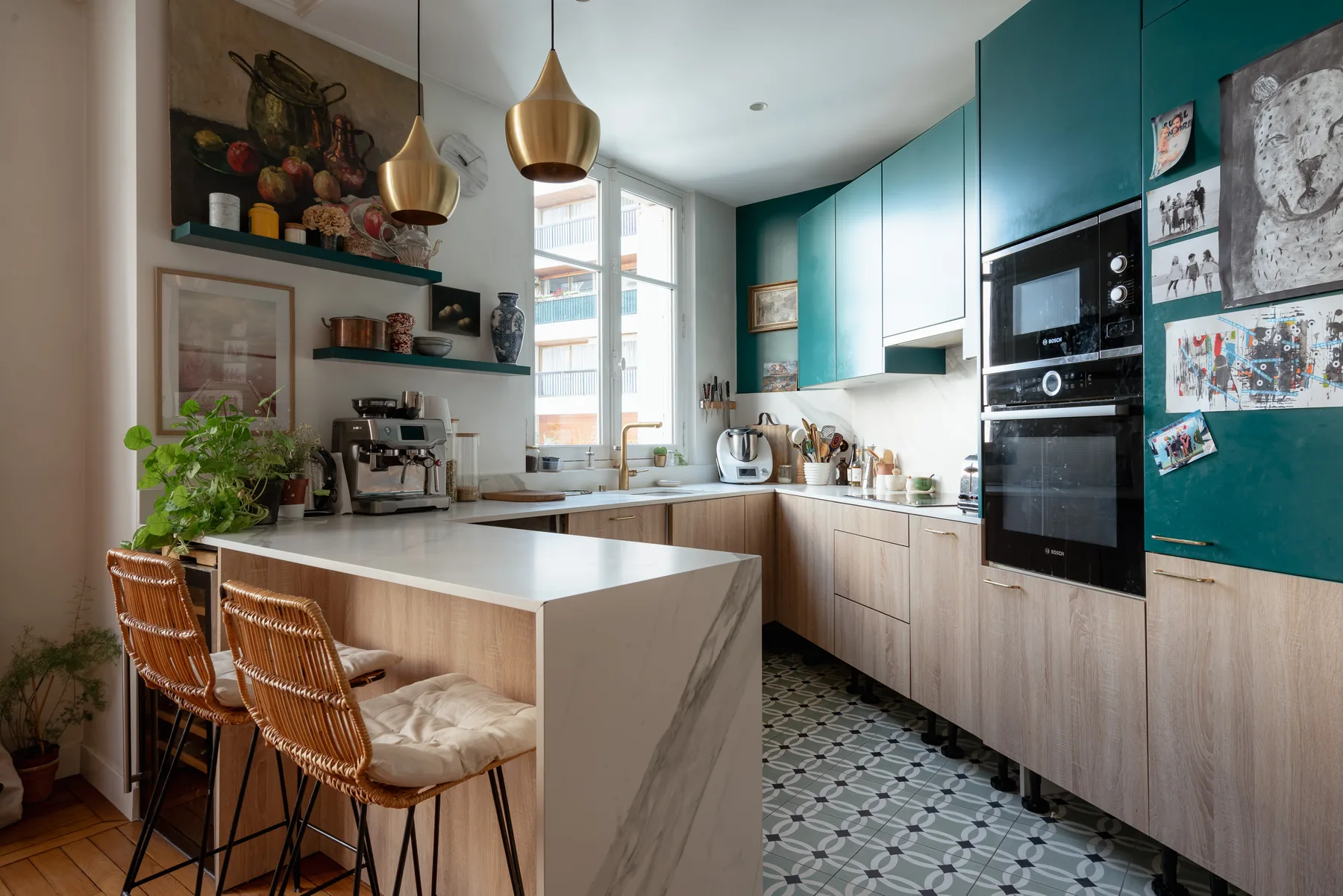 A bright kitchen with teal cabinets, a central island, and woven seating.